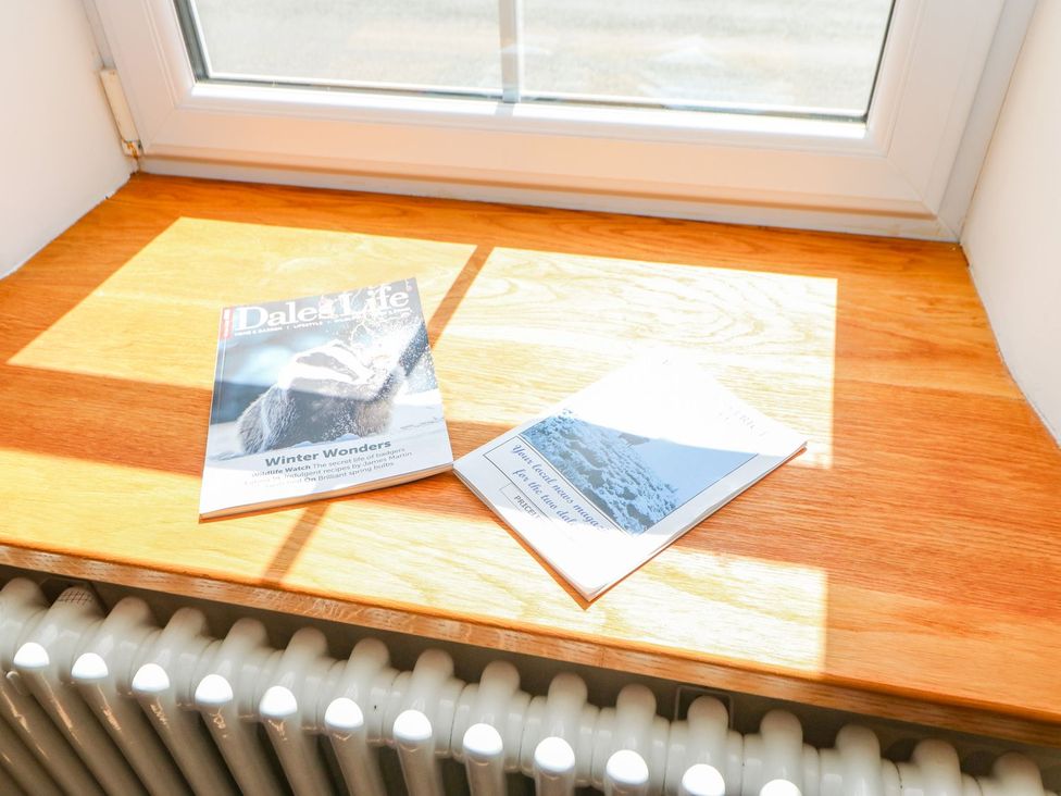 Magazines on a wooden windowsill with a radiator at Wayside Farm Richmond