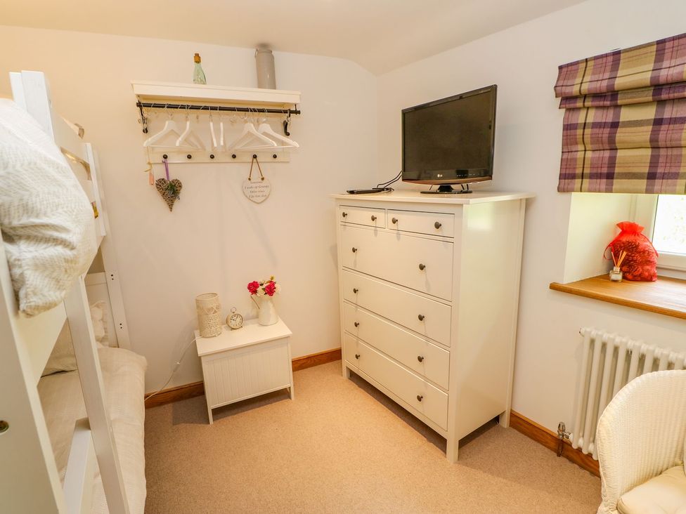 A bedroom with a bunk bed and television at Wayside Farm in Richmond