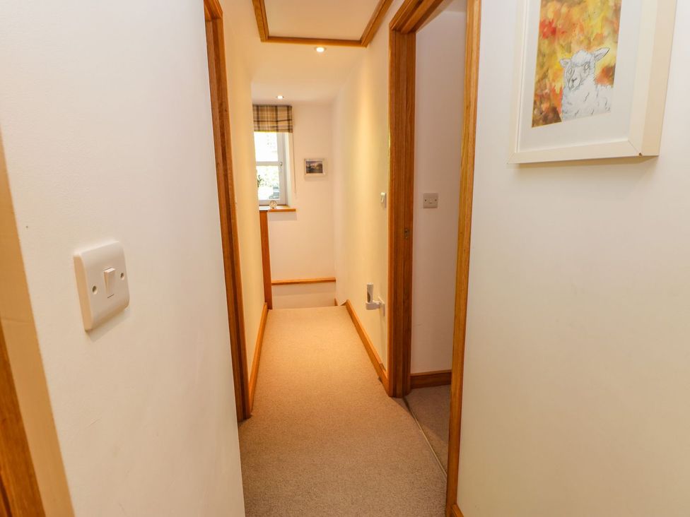 A hallway with carpet and a light switch at Wayside Farm in Richmond