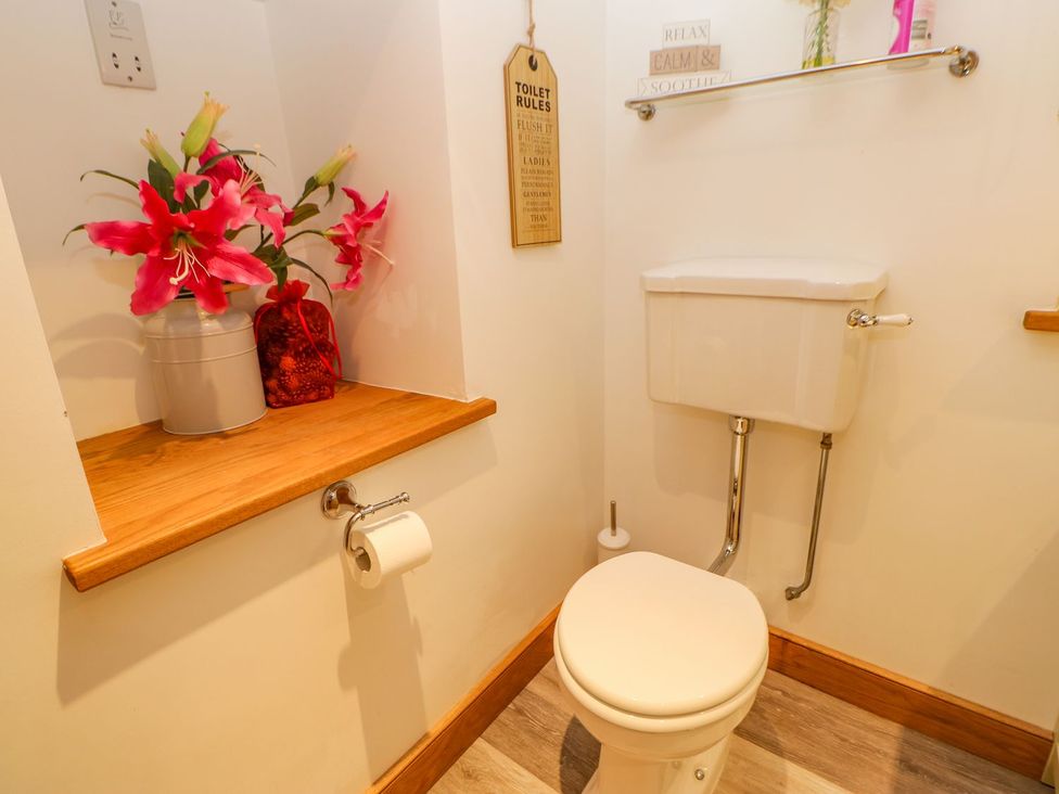 A bathroom with a toilet and shelf at Wayside Farm Richmond