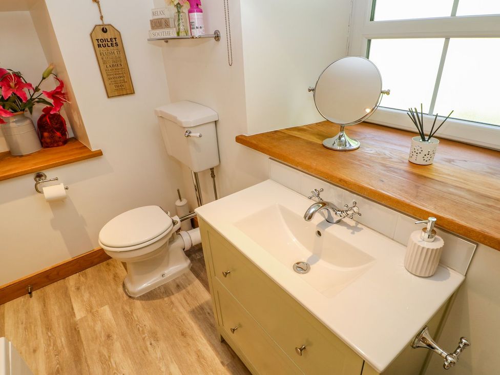 A bathroom with a toilet, sink and mirror at Wayside Farm in Richmond
