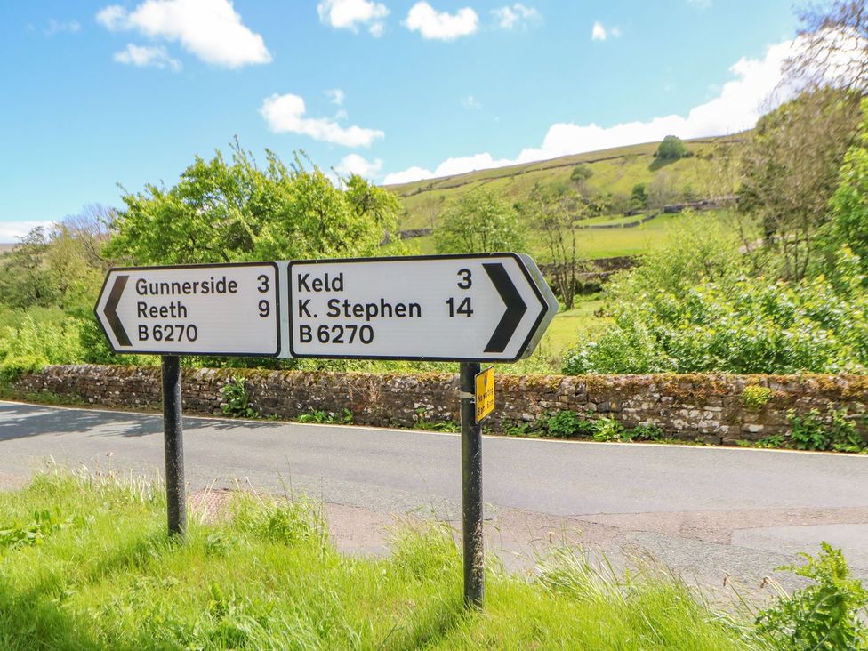 A road sign indicating distances to Gunnerside, Reeth, and Keld at Wayside Farm in Richmond