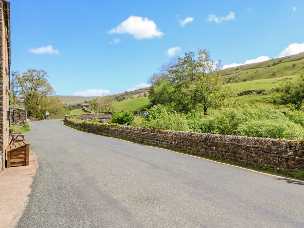 A road with a stone wall and trees at Wayside Farm in Richmond