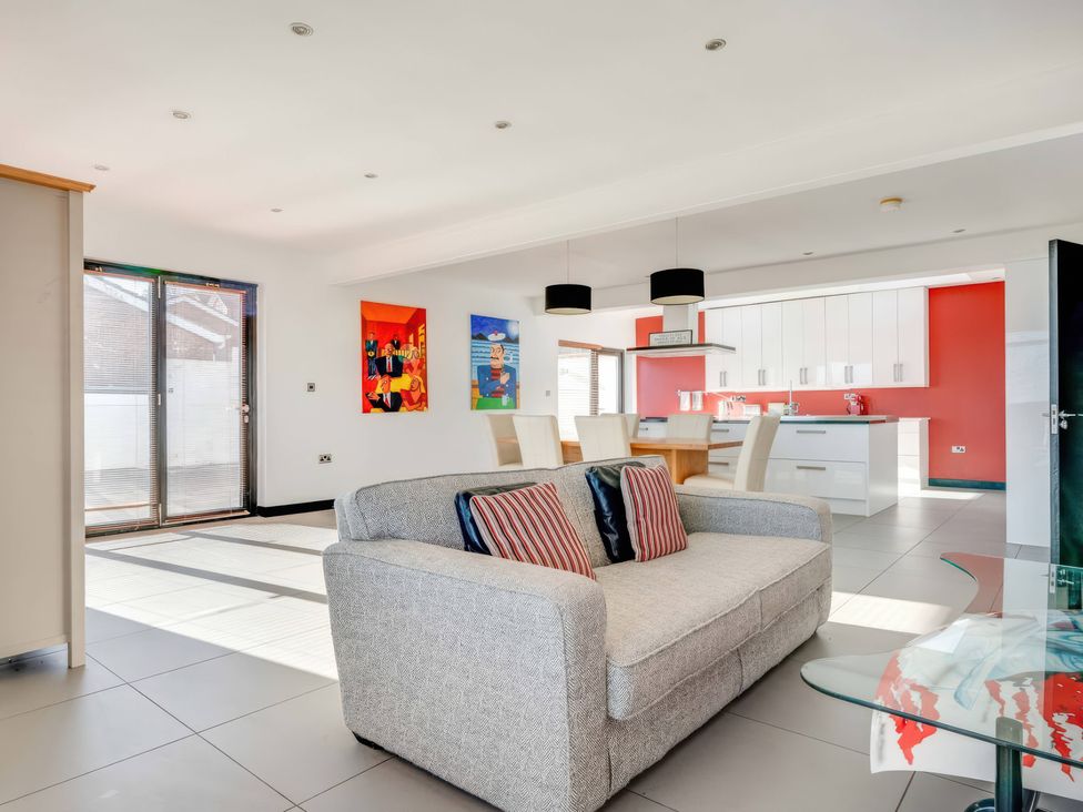 A living room with a sofa and kitchen area at Bellevue