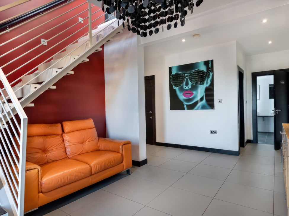 A living room with a sofa and staircase at Bellevue 