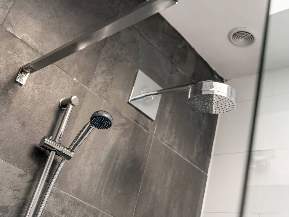 A shower system with handheld and overhead showerhead at Bellevue 