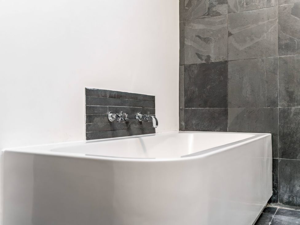 A bathtub with faucet and tile wall at Bellevue