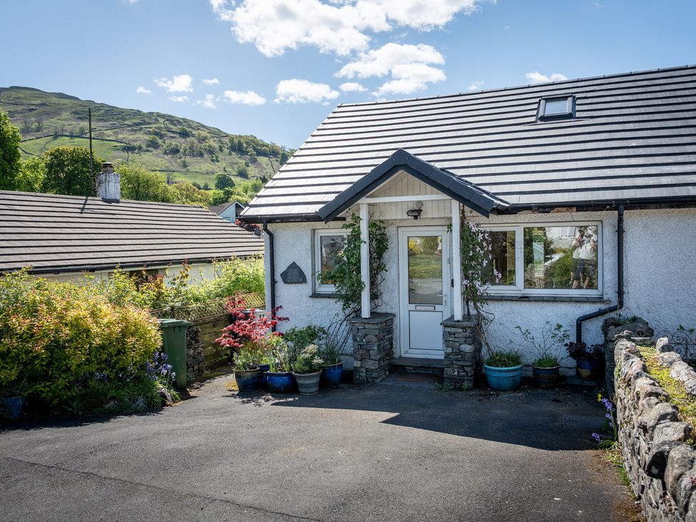 A house with a garden and driveway at Oaks Lodge Cottage in Ambleside