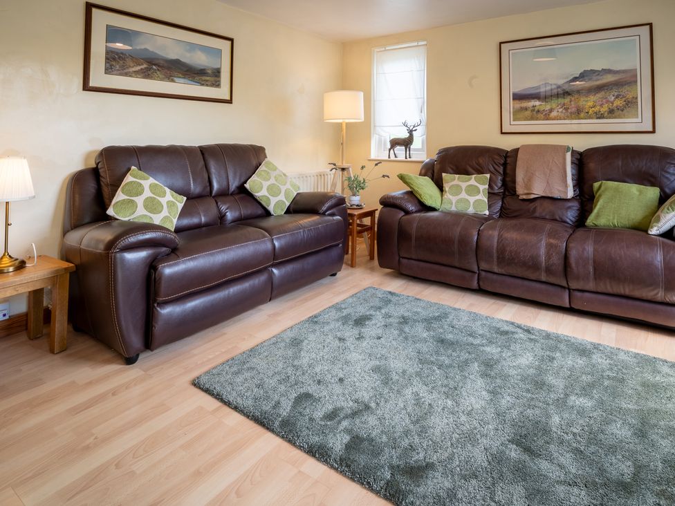 A living room with two sofas and a lamp at Oaks Lodge Cottage in Ambleside