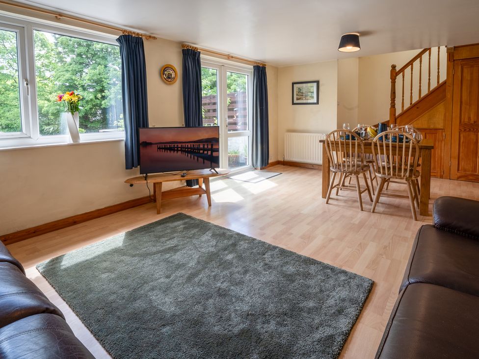 A living room with a sofa and television at Oaks Lodge Cottage in Ambleside