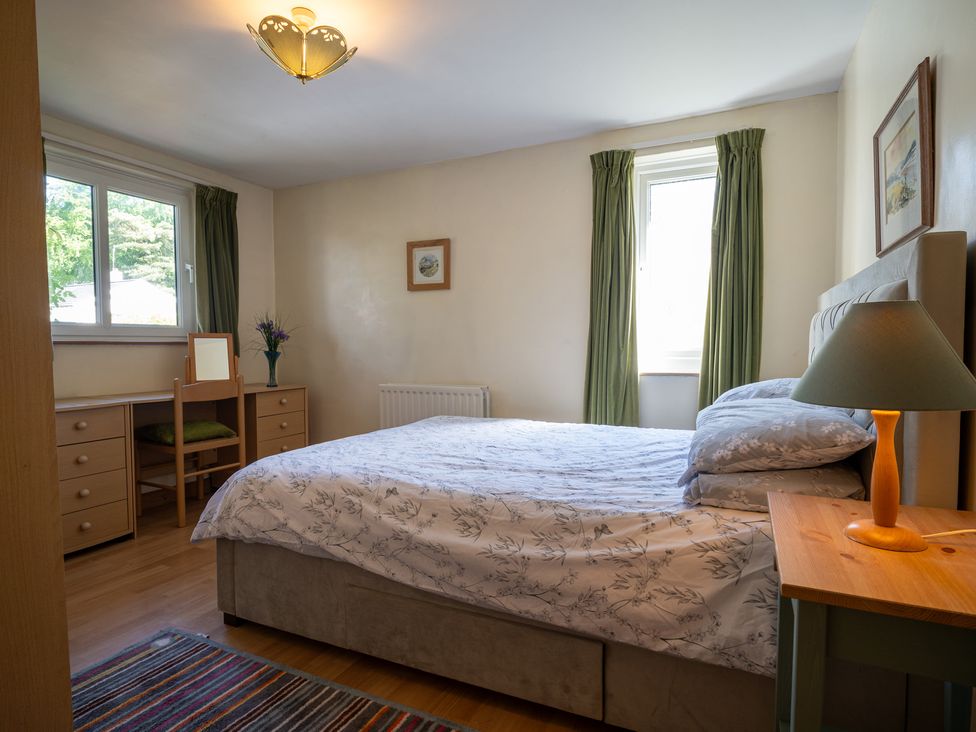 A bedroom with a bed and a desk at Oaks Lodge Cottage Ambleside