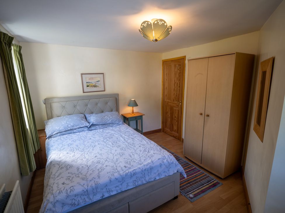 A bedroom with a bed and wardrobe at Oaks Lodge Cottage in Ambleside