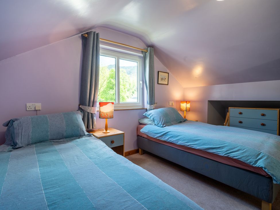 A bedroom with two beds and a window at Oaks Lodge Cottage in Ambleside
