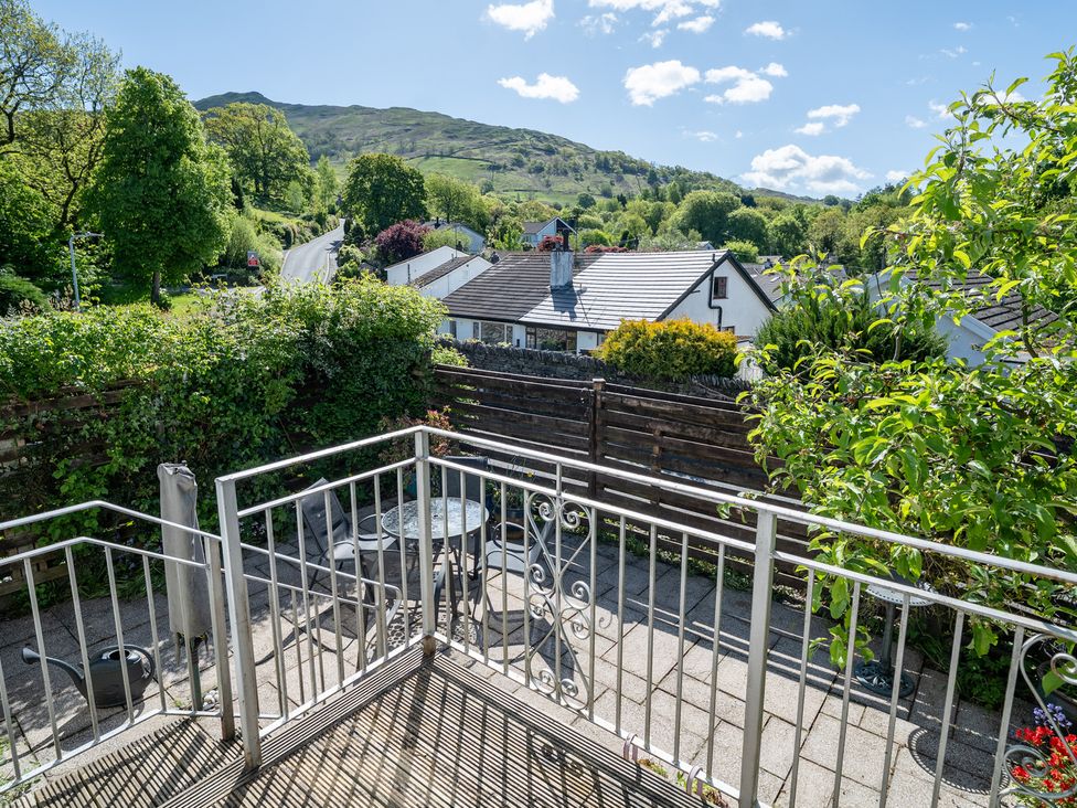An outdoor area with a balcony and table at Oaks Lodge Cottage in Ambleside