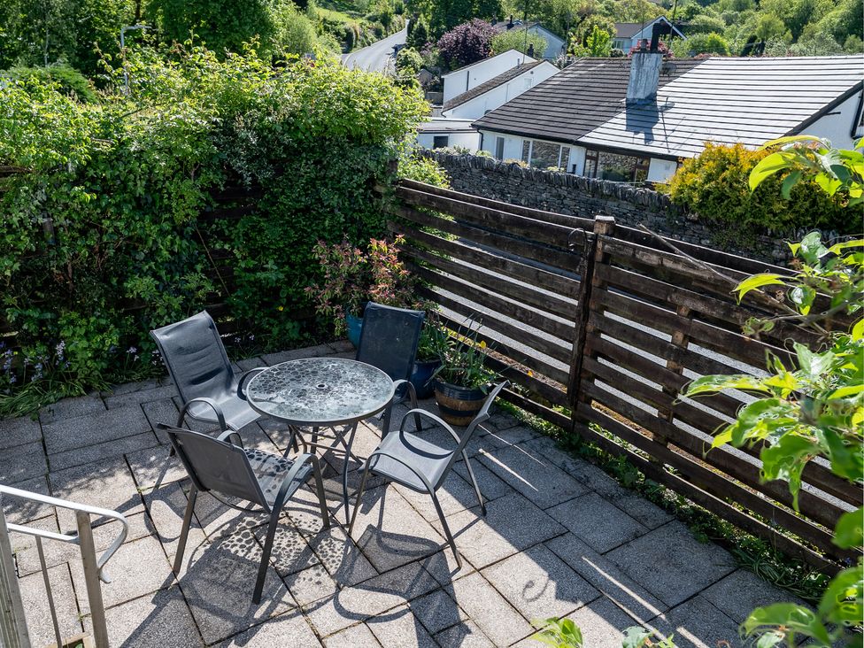 A garden with a table and chairs at Oaks Lodge Cottage in Ambleside