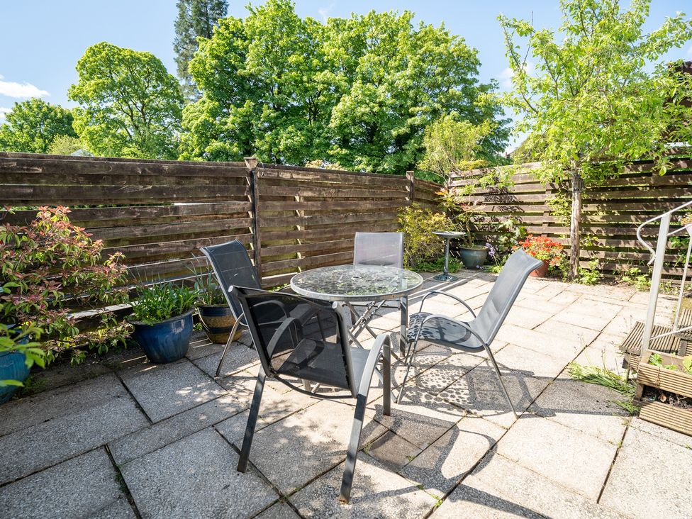 A garden with a table and chairs at Oaks Lodge Cottage Ambleside
