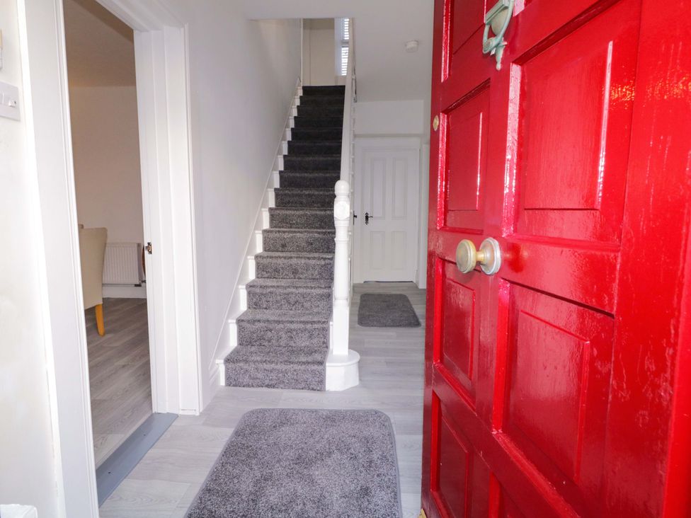 A hallway with a red front door and staircase at San Antonio, Dungloe, County Donegal