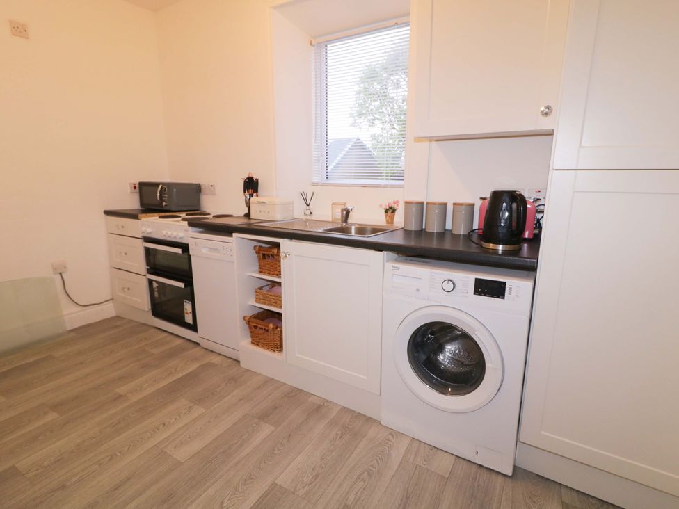 A kitchen with an oven, washing machine, and sink at San Antonio in Dungloe, County Donegal