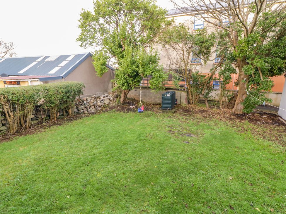A garden with grass, trees, and a swing at San Antonio Dungloe, County Donegal