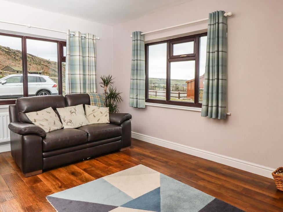 A living room with a sofa and window at Baywood Cottage in Keighley