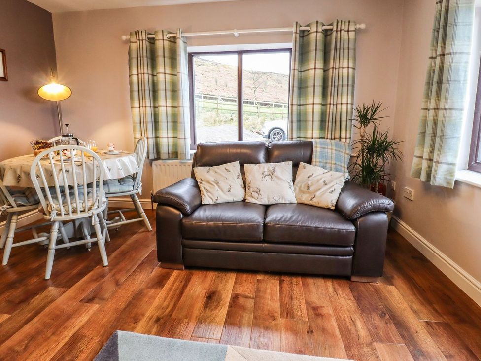 A living room with a sofa and dining table at Baywood Cottage in Keighley