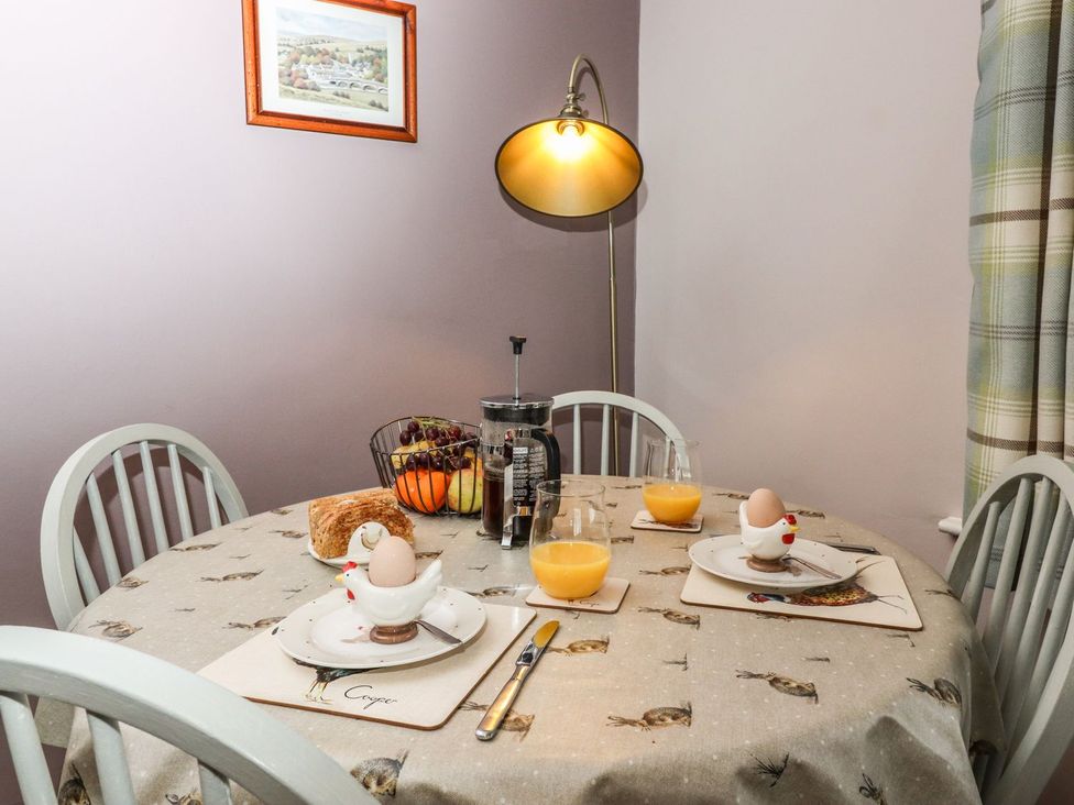 A dining table with eggs and orange juice at Baywood Cottage in Keighley