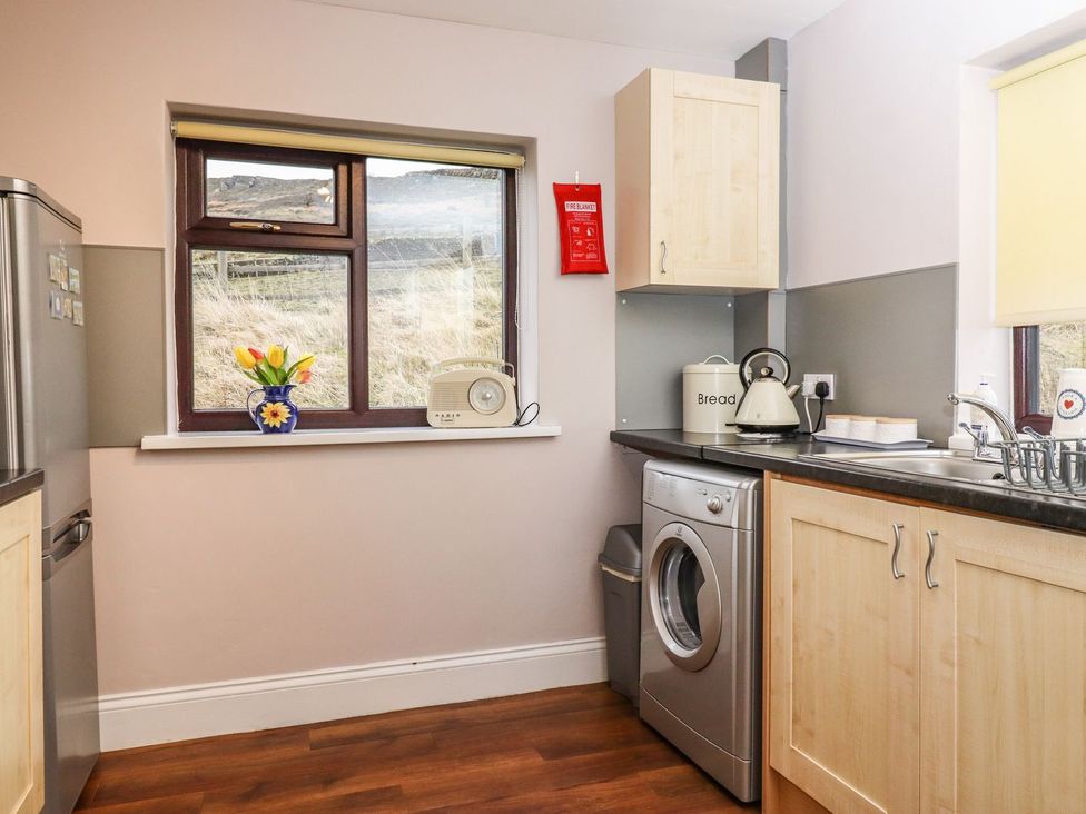 A kitchen with modern appliances and a view at Baywood Cottage in Keighley