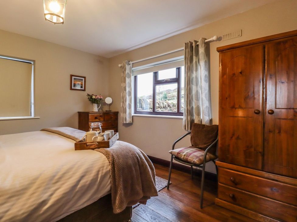 A bedroom with a bed and wardrobe at Baywood Cottage in Keighley
