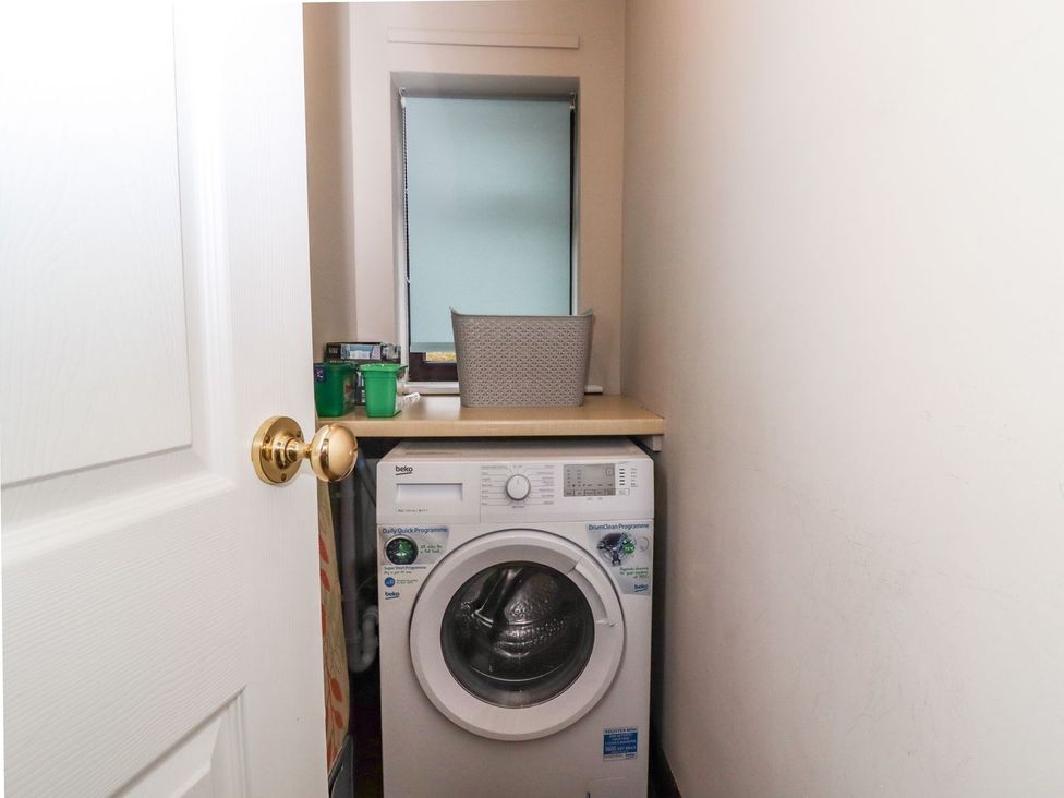 A laundry room with a washing machine and countertop at Baywood Cottage in Keighley