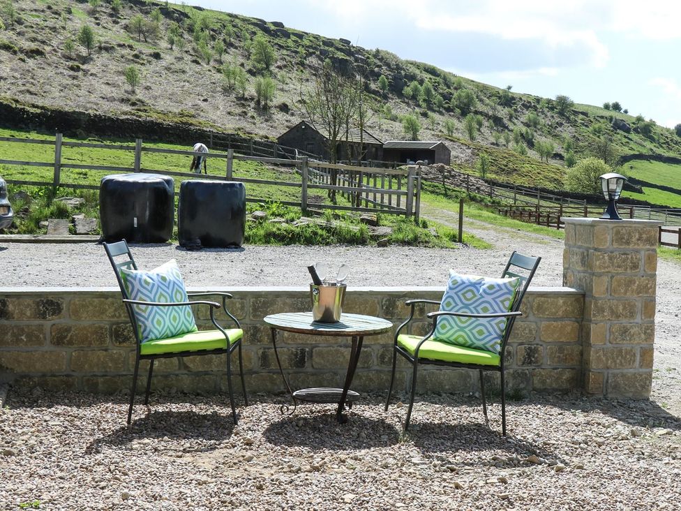 A seating area with chairs and a table at Baywood Cottage in Keighley