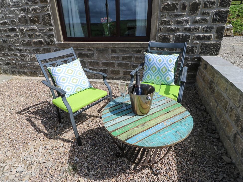 A seating area with two chairs and a table at Baywood Cottage in Keighley