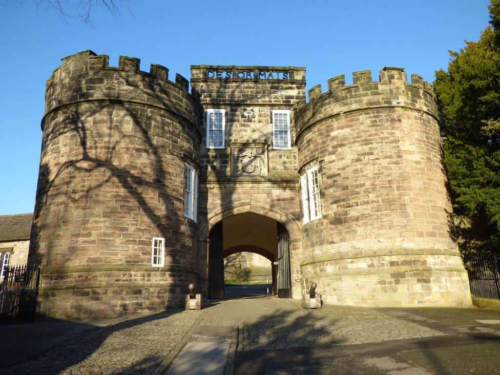 A stone gate with towers and archway at Baywood Cottage in Keighley