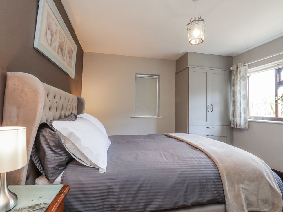 A bedroom with a bed and wardrobe at Baywood Cottage in Cowling