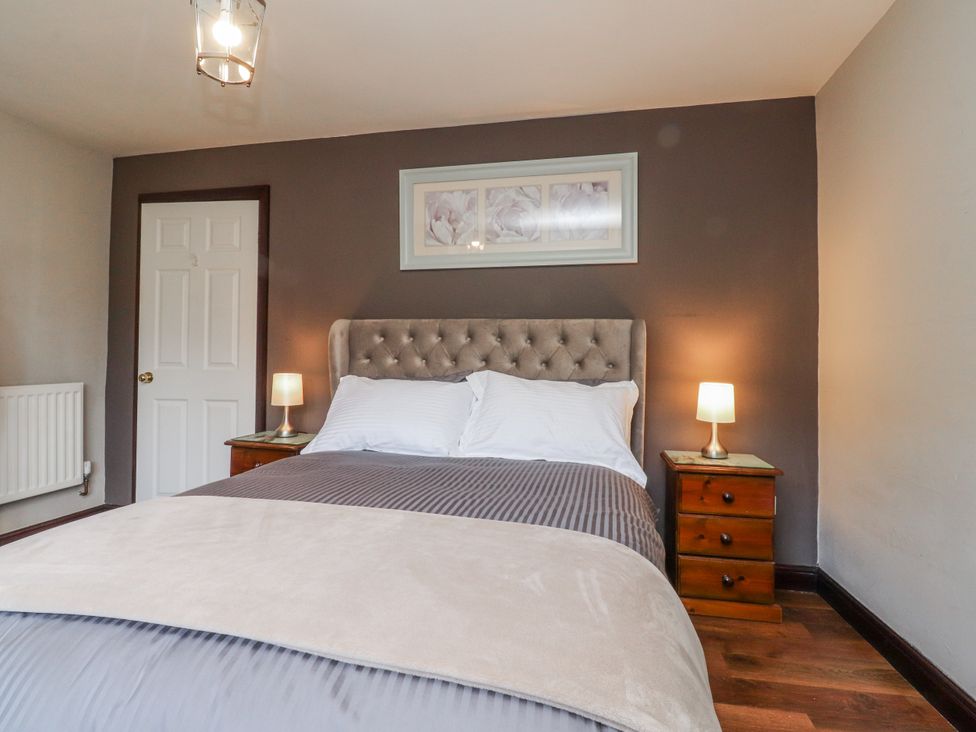 A bedroom with a bed and bedside tables at Baywood Cottage in Cowling
