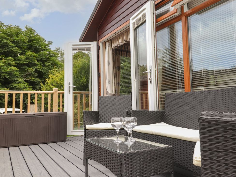 An outdoor seating area with a sofa and table at Kingfisher Lodge in Windermere