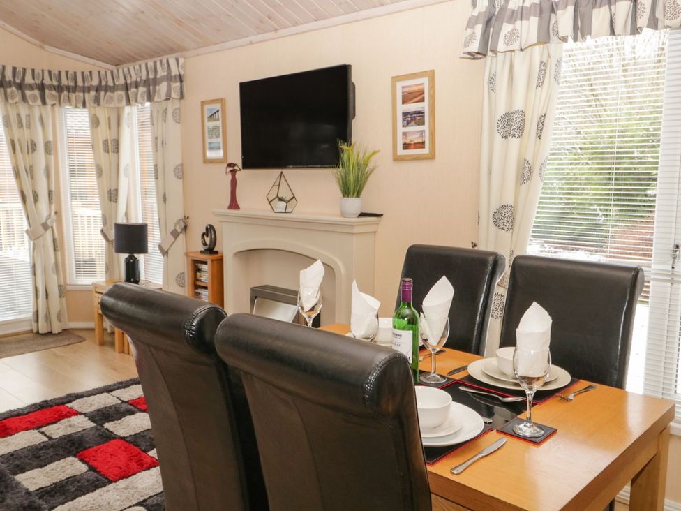 A dining room with a table set for dinner at Kingfisher Lodge in Windermere