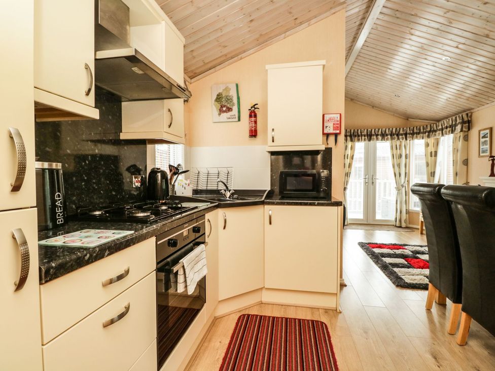 A kitchen with cabinets and appliances at Kingfisher Lodge in Windermere