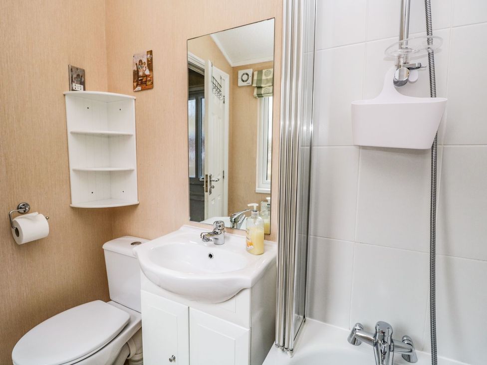 A bathroom with a sink, toilet, and shower at Kingfisher Lodge in Windermere