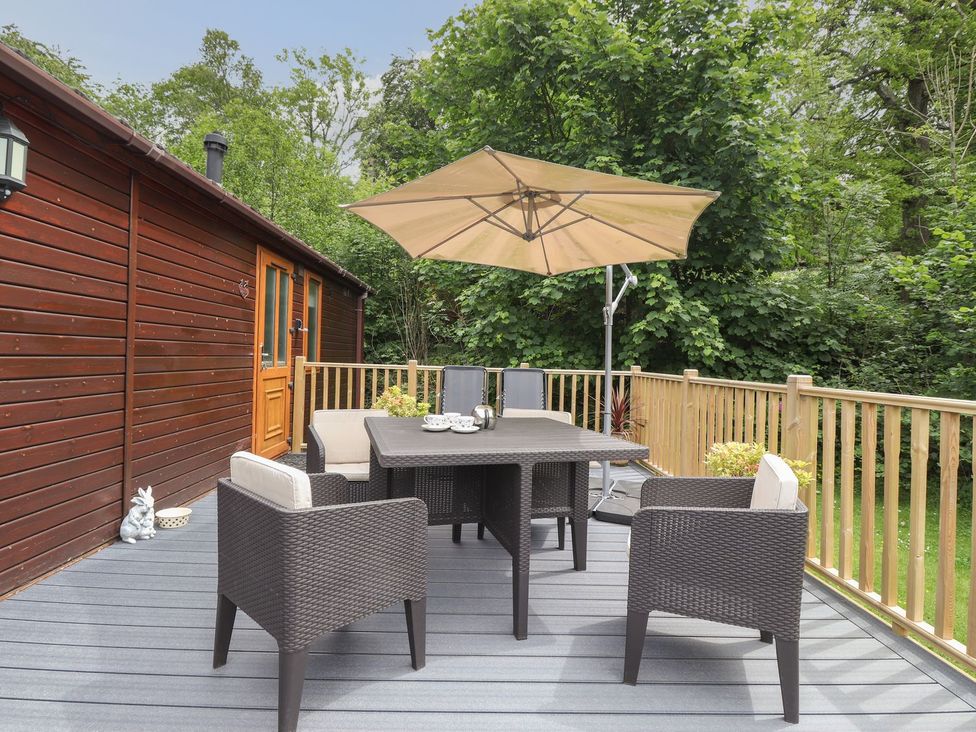 A outdoor seating area with a table and chairs at Kingfisher Lodge in Windermere
