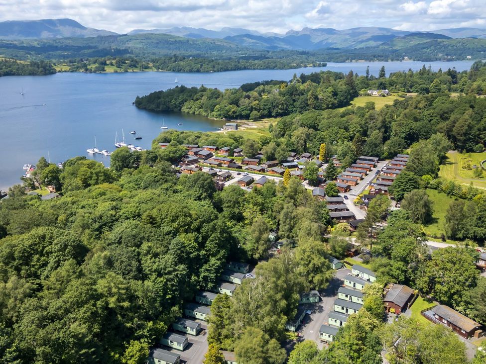An aerial view of a lakeside property with wooden houses and boats at Kingfisher Lodge in Windermere