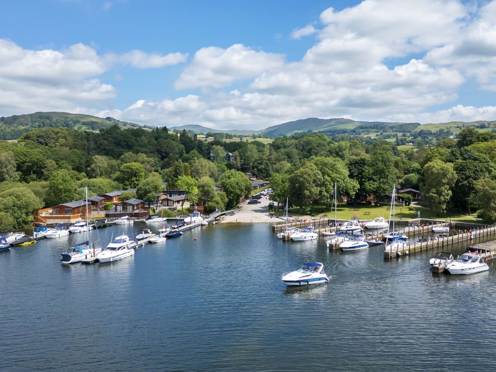 A harbor with boats and green trees at Kingfisher Lodge in Windermere