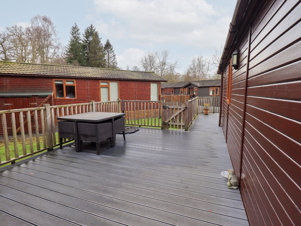 An outdoor area with decking and a table at Kingfisher Lodge in Grasmere 33, White Cross Bay near Windermere