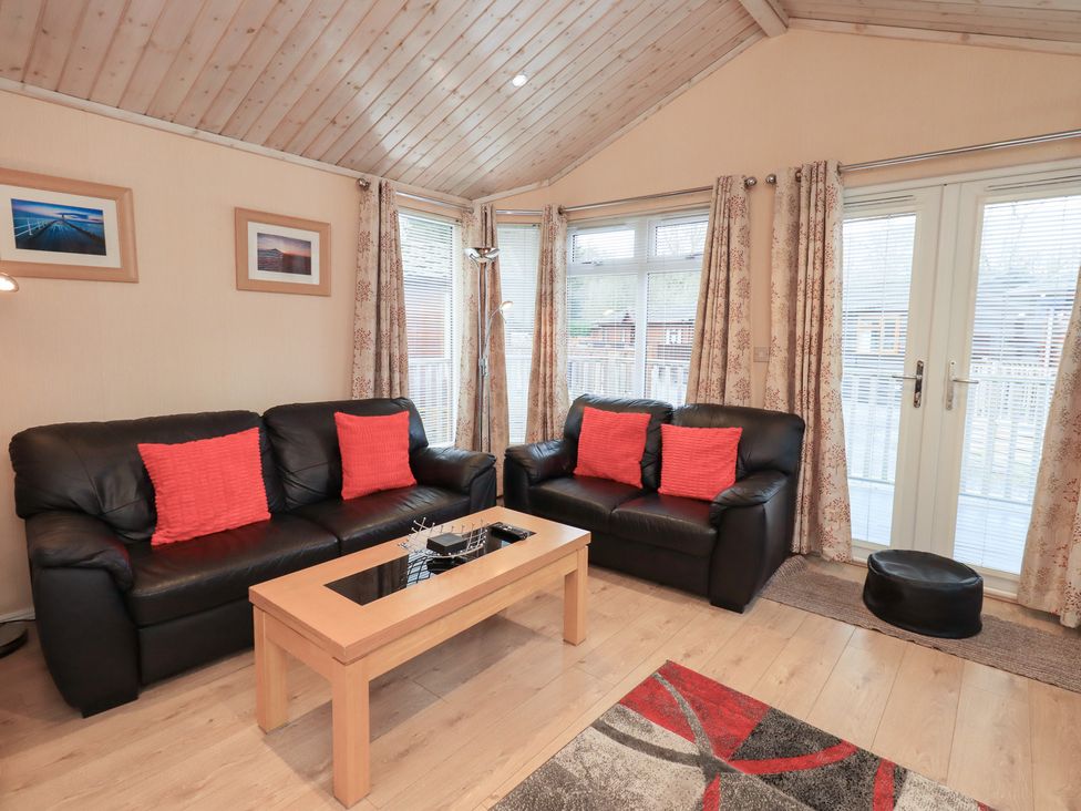 A living room with sofas and a coffee table at Kingfisher Lodge Grasmere 33, White Cross Bay near Windermere