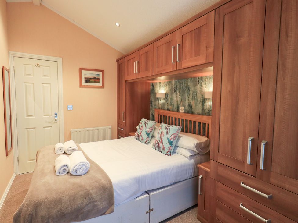 A bedroom with a bed and wardrobe at Kingfisher Lodge, Grasmere 33, White Cross Bay near Windermere