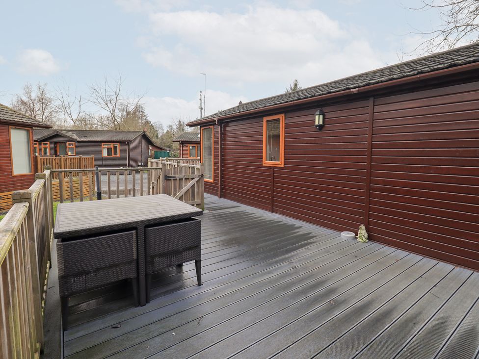 An outdoor area with decking and a table at Kingfisher Lodge, Grasmere 33, White Cross Bay near Windermere