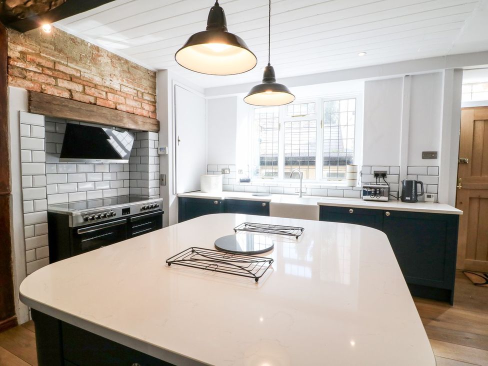 A kitchen with an island, stove and sink at The Old Bakery in Banbury