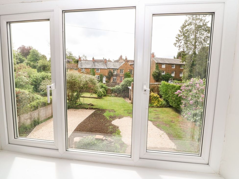 A view from a window showing a garden and houses at The Old Bakery in Banbury