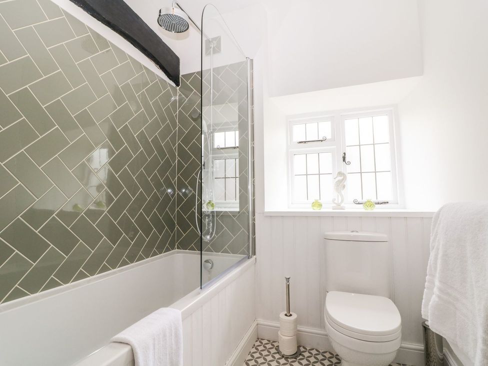 A bathroom with a bathtub and toilet at The Old Bakery in Banbury
