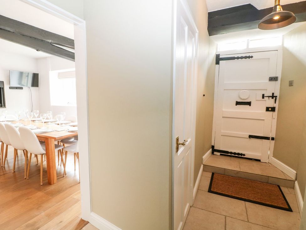 A hallway with a door and view of a dining area at The Old Bakery in Banbury