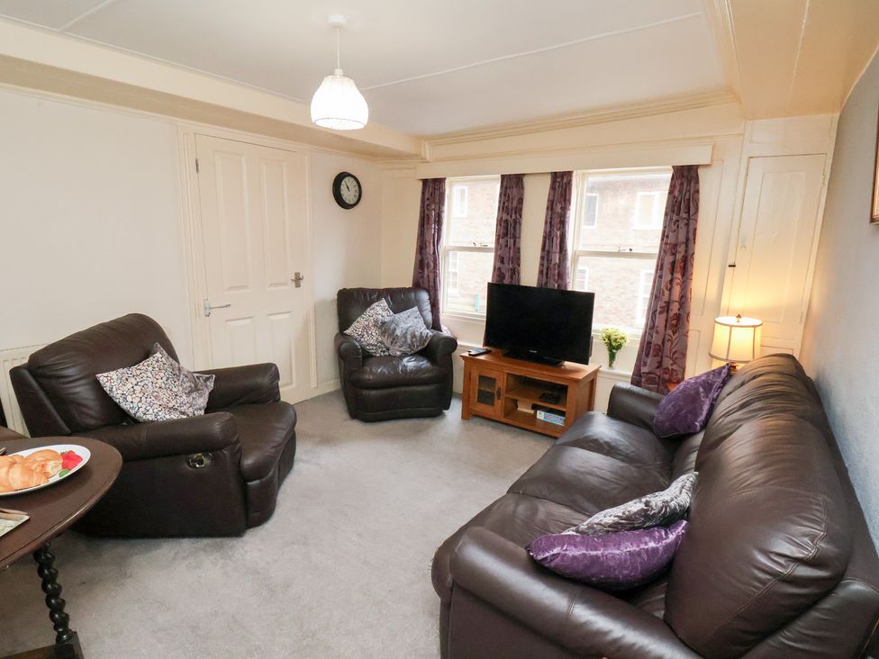 A living room with a sofa and television at Stowaway Cottage in Whitby